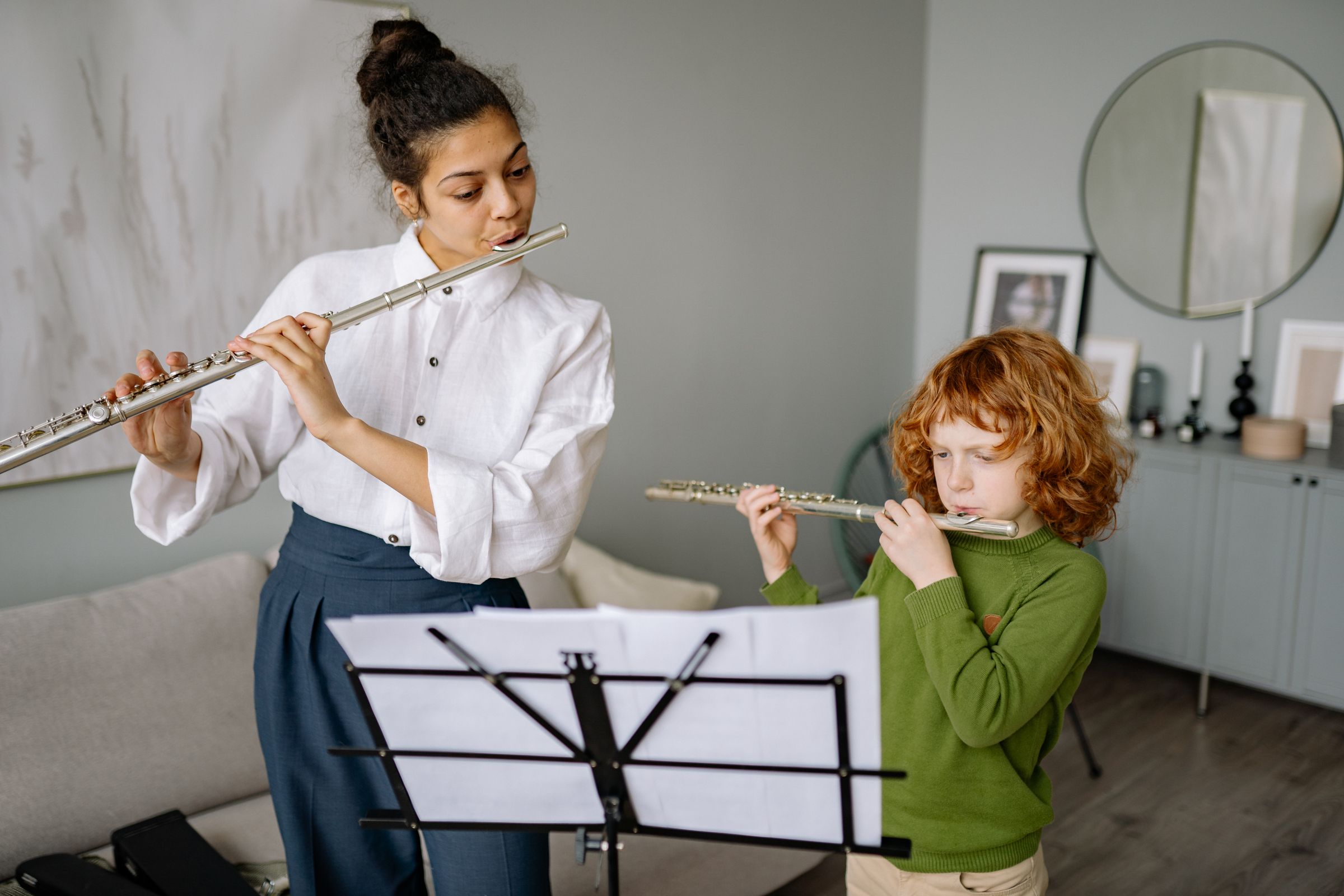 A child learning flute with a music teacher