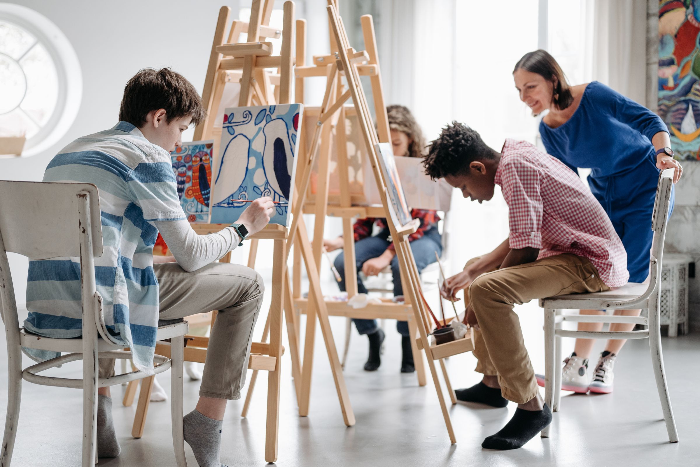 An activity provider guiding children through an art class