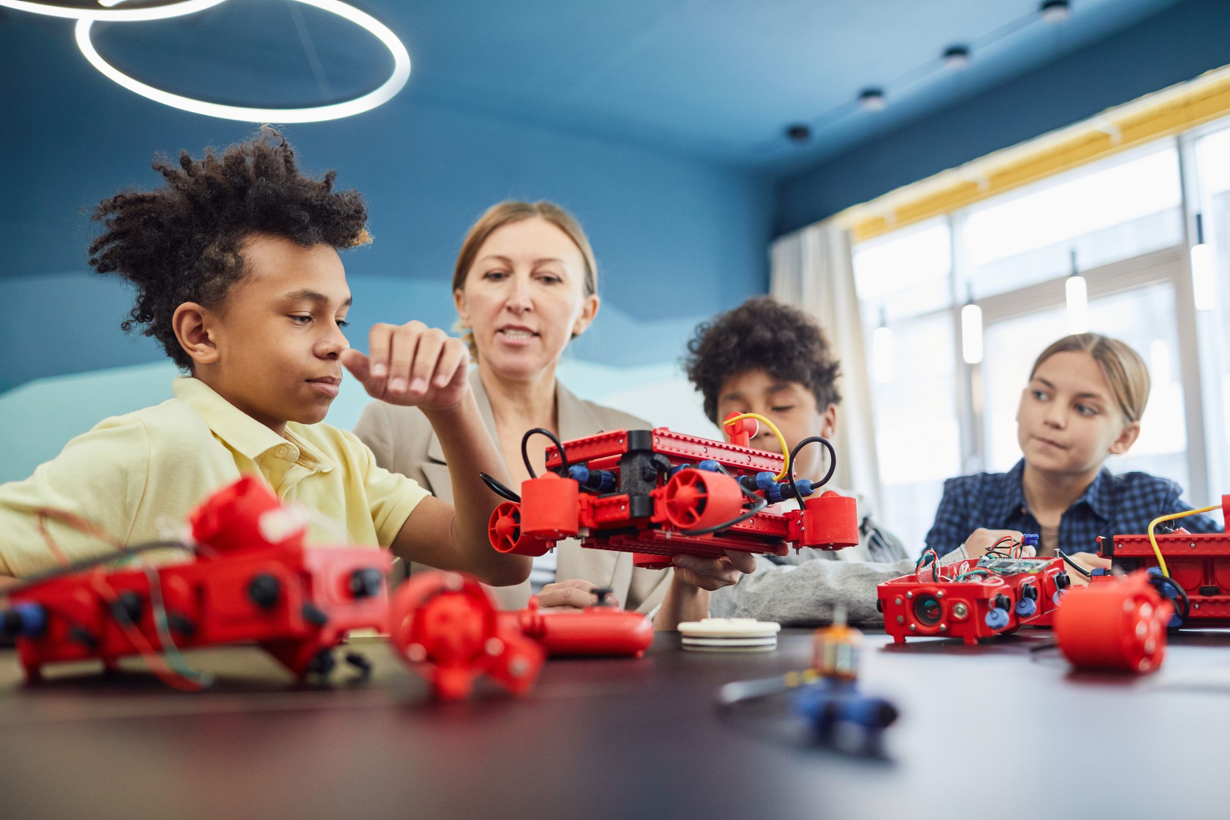 Children building a robotics project with a teacher